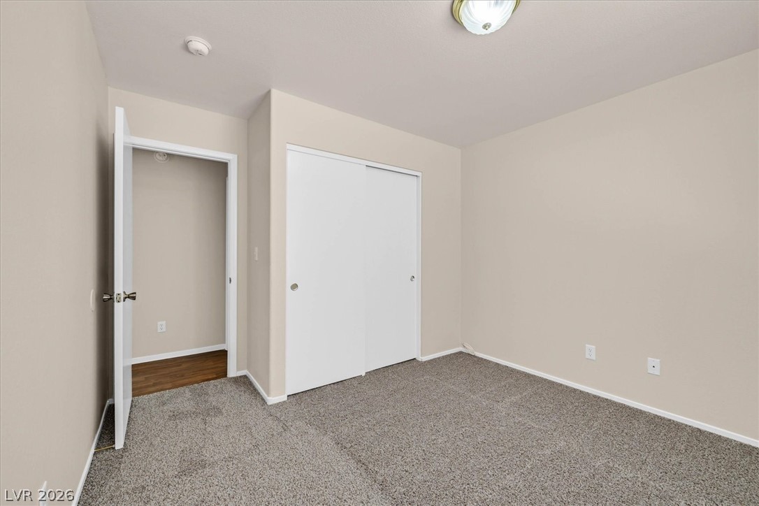 330 Warm Front Street Henderson, NV 89014 - Photo 11 of 25 This cozy bedroom features plush carpeting and a convenient closet, perfect for comfortable living.