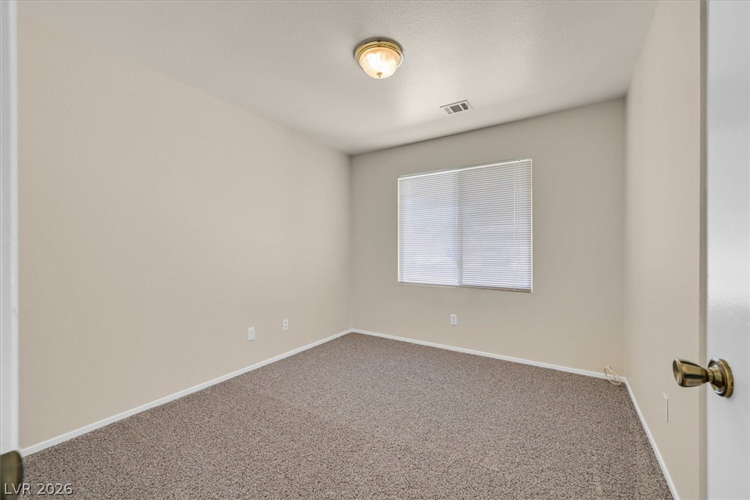 330 Warm Front Street Henderson, NV 89014 - Photo 13 of 25 This spacious bedroom offers ample natural light and plush carpeting for comfort.