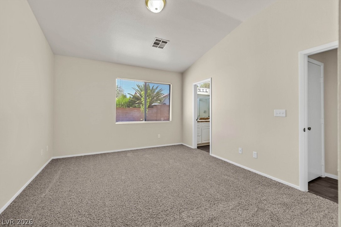 330 Warm Front Street Henderson, NV 89014 - Photo 18 of 25 This airy bedroom offers comfortable living with soft carpet and a convenient en-suite bathroom access.
