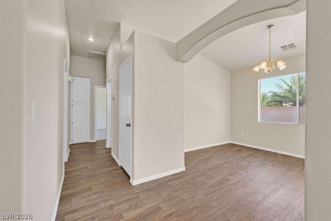 330 Warm Front Street Henderson, NV 89014 - Photo 5 of 25 Warm wood flooring extends throughout this versatile space, featuring an inviting archway.