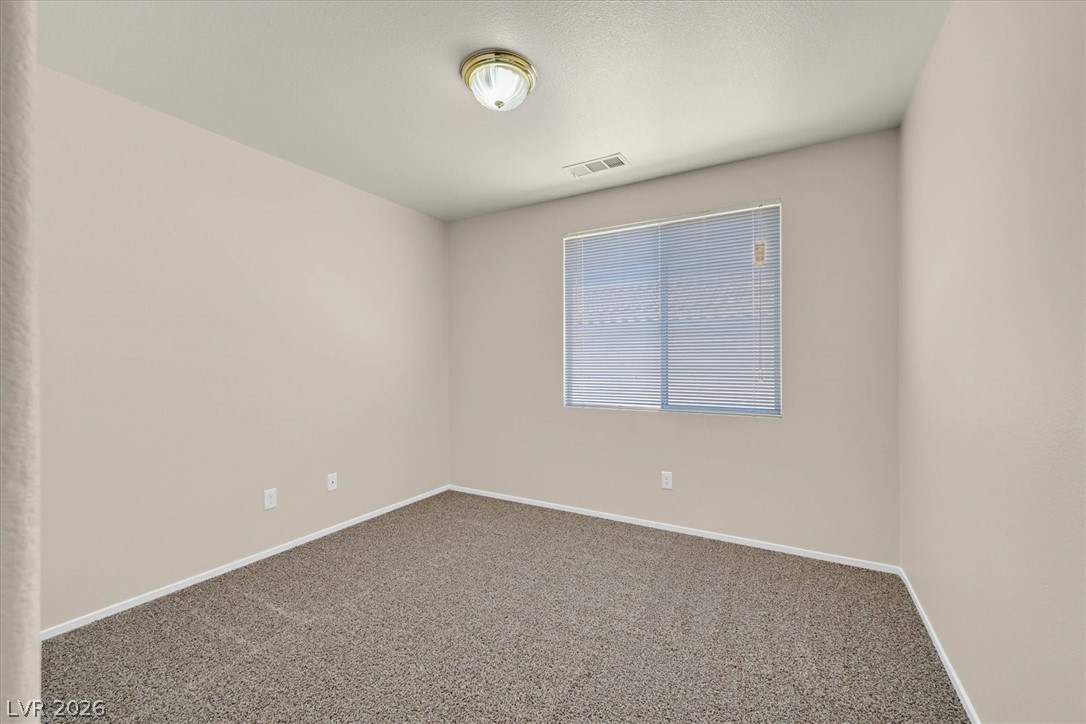 330 Warm Front Street Henderson, NV 89014 - Photo 10 of 25 This cozy bedroom offers a tranquil retreat with soft carpet and a large window providing ample light.