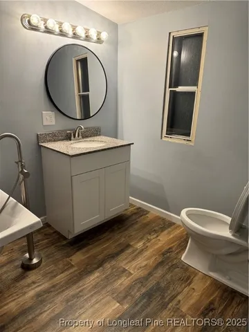 a bathroom with a toilet a sink and mirror