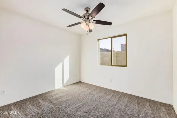 an empty room with windows and fan