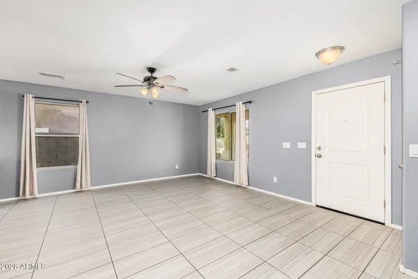 an empty room with fan and windows
