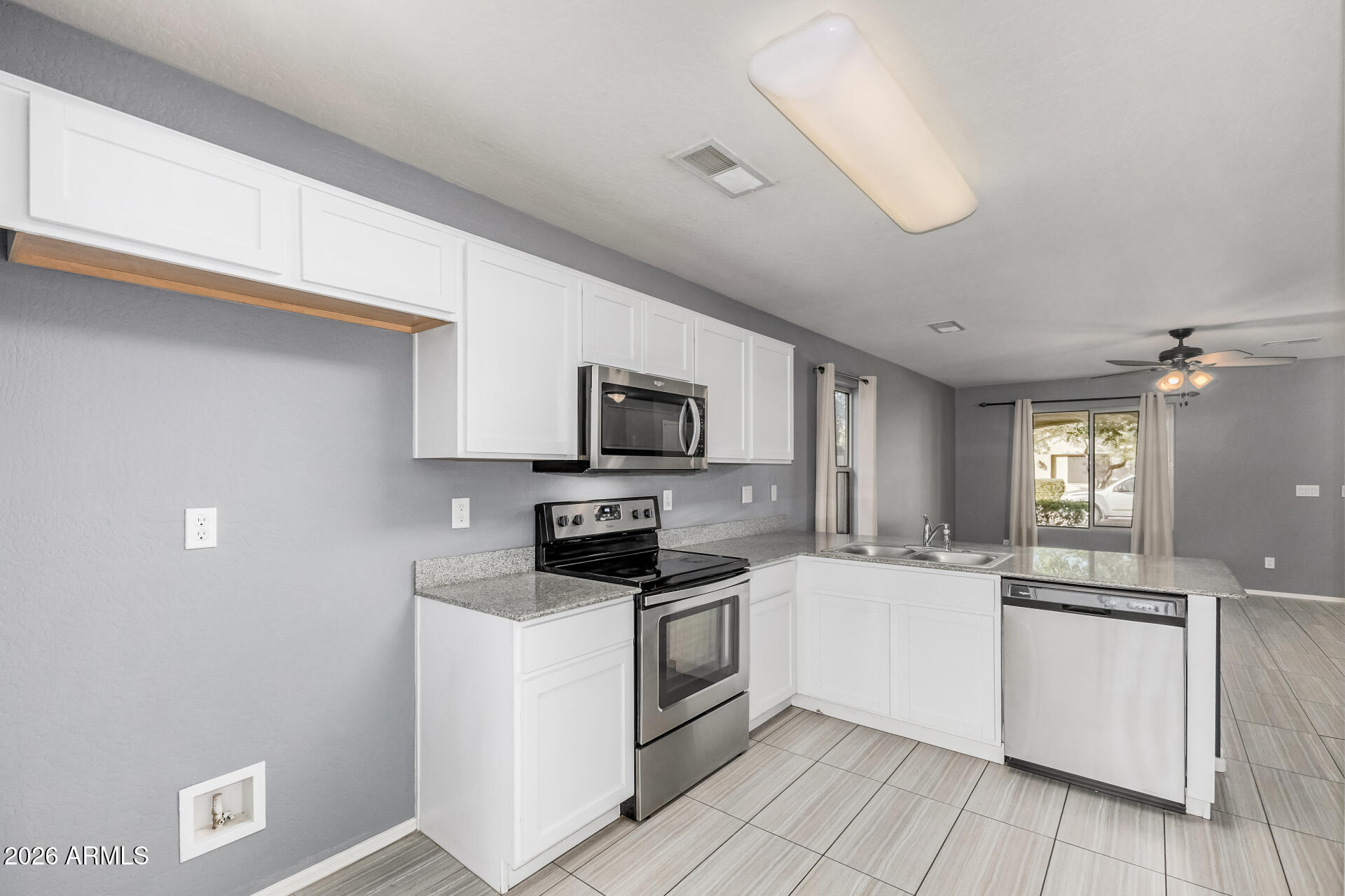 1877 West Rd Agent Street Apache Junction, AZ 85120 - Photo 10 of 24 a kitchen with stainless steel appliances a white stove top oven a sink dishwasher and a refrigerator with wooden floor