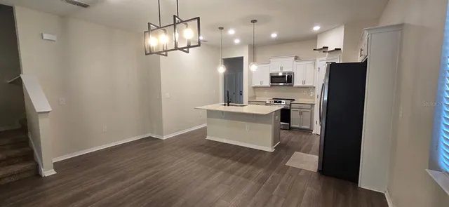 a kitchen with kitchen island white cabinets and stainless steel appliances
