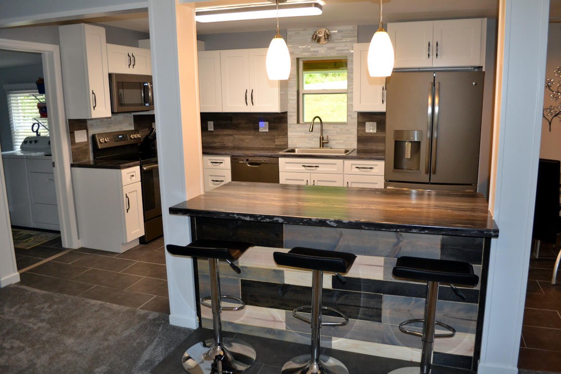 1481 Dutch Valley Road Clinton, TN 37716 - Photo 6 of 24 a kitchen with granite countertop a refrigerator cabinets and wooden floor