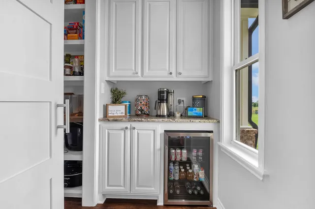 a kitchen with white cabinets and window