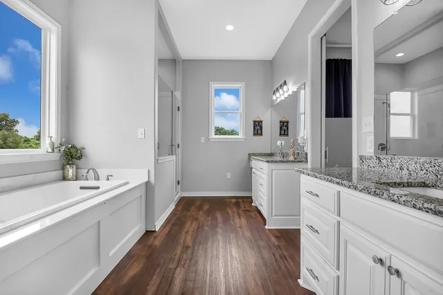 a bathroom with a sink a large mirror and a bathtub