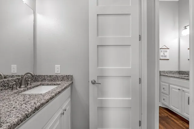 a bathroom with a granite countertop sink and a mirror