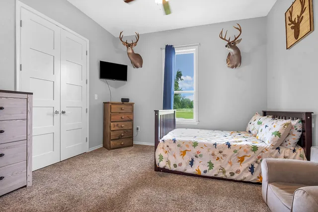 a bedroom with furniture and a flat tv screen