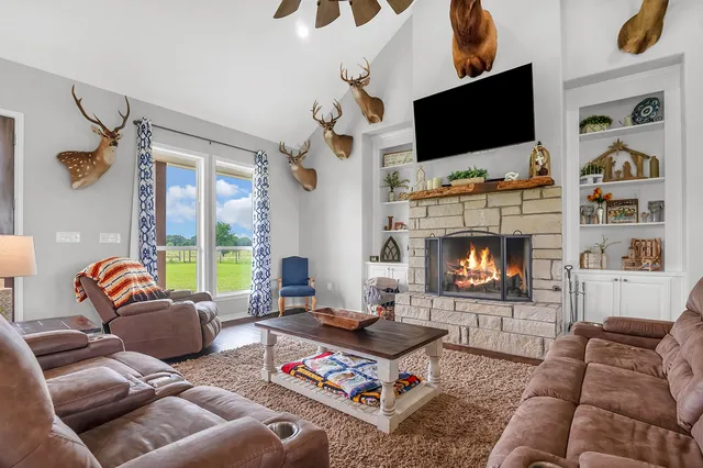 a living room with furniture a flat screen tv and a fireplace