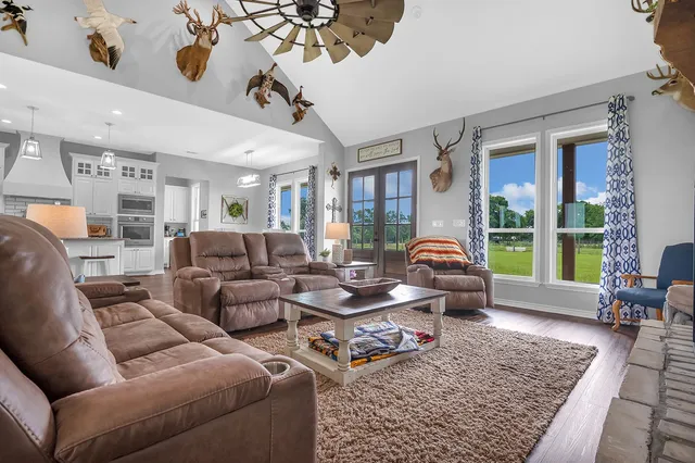 a living room with furniture fireplace and large windows