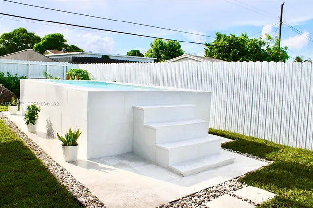 a front view of a house with a yard and potted plant