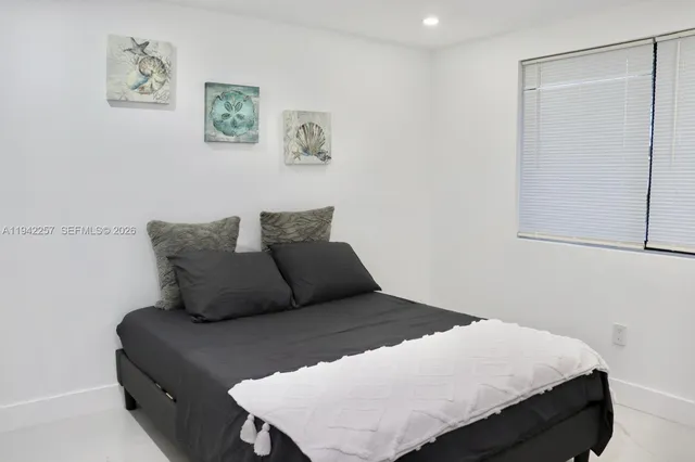 a bedroom with a bed and painting on the wall