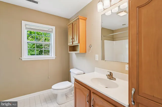 a bathroom with a sink a toilet and a window