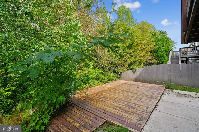 a patio with table and chairs and potted plants