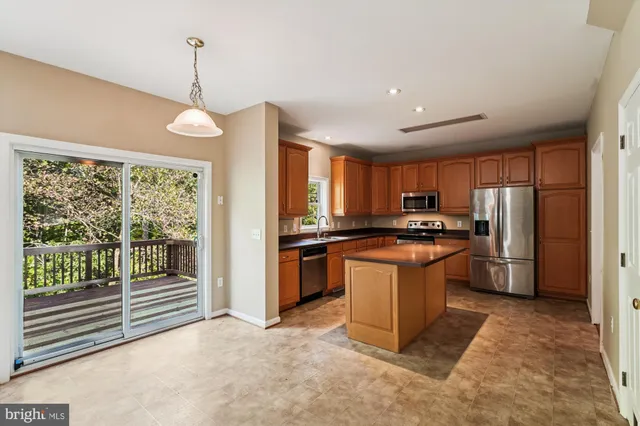 a kitchen with stainless steel appliances granite countertop a refrigerator a stove a sink and a refrigerator