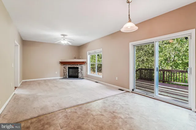 a view of an empty room with a fireplace and a window