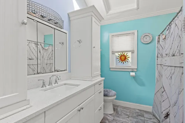 a bathroom with a granite countertop sink a toilet and a mirror