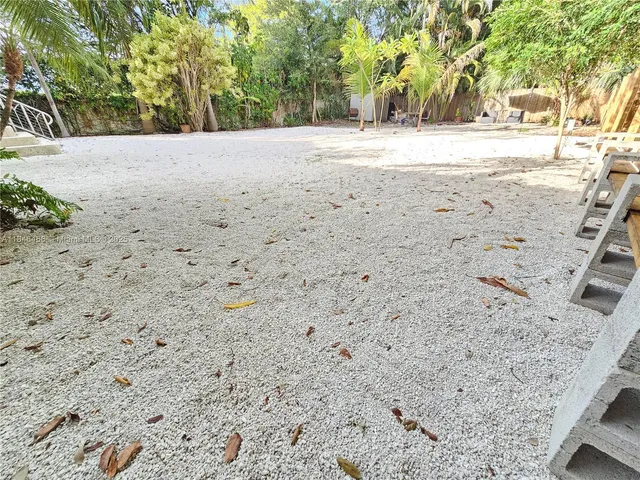 a view of dirt yard with a large tree