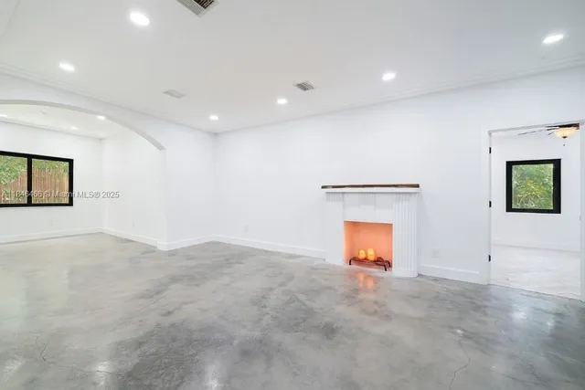 an empty room with a window and a ceiling fan