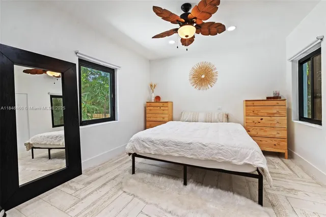 a bedroom with a bed and dresser with mirror