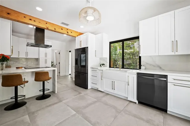 a kitchen with stainless steel appliances kitchen island granite countertop a refrigerator and a sink