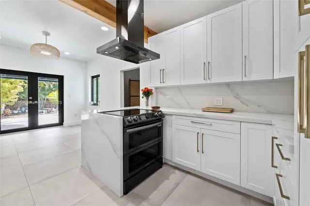 a kitchen with stainless steel appliances granite countertop a stove a sink and a refrigerator with white cabinets