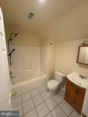 a bathroom with a granite countertop sink a toilet and a shower