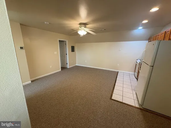 an empty room with a ceiling fan and a window