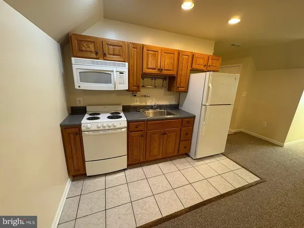 a kitchen with a stove a sink and a refrigerator