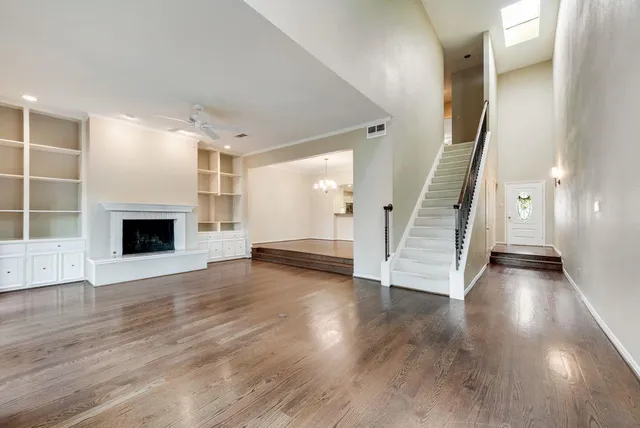 a view of a livingroom with wooden floor and a fireplace
