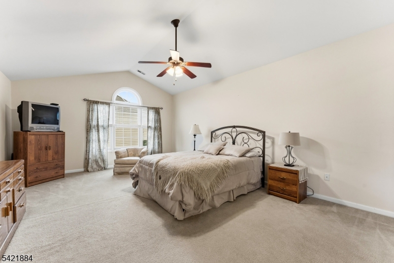 26 Rouser Way Hillsborough, NJ 08844 - Photo 30 of 49 a bedroom with a bed a chandelier and a flat tv screen on a dresser
