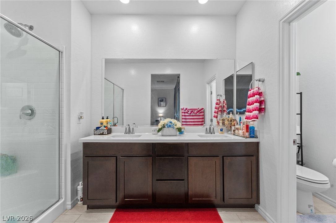 8879 Roadrunner Ravine Street Las Vegas, NV 89166 - Photo 22 of 39 Double vanity with ample storage and a contemporary shower create a clean, functional bathroom space.