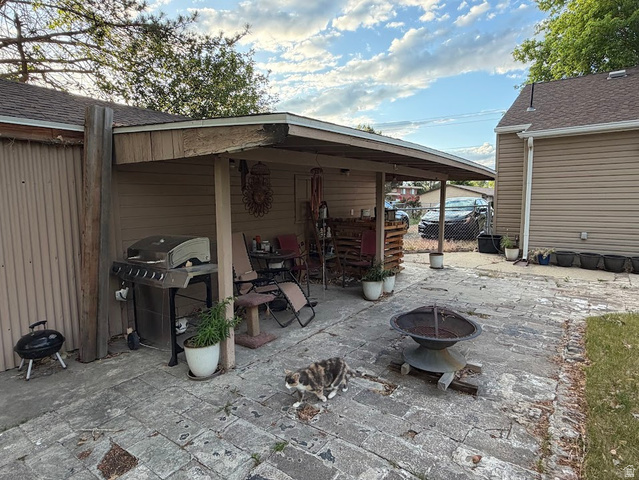 737 Wasatch Street Midvale, UT 84047 - Photo 29 of 29 Paved patio area featuring a covered outdoor structure and a built-in fire pit
