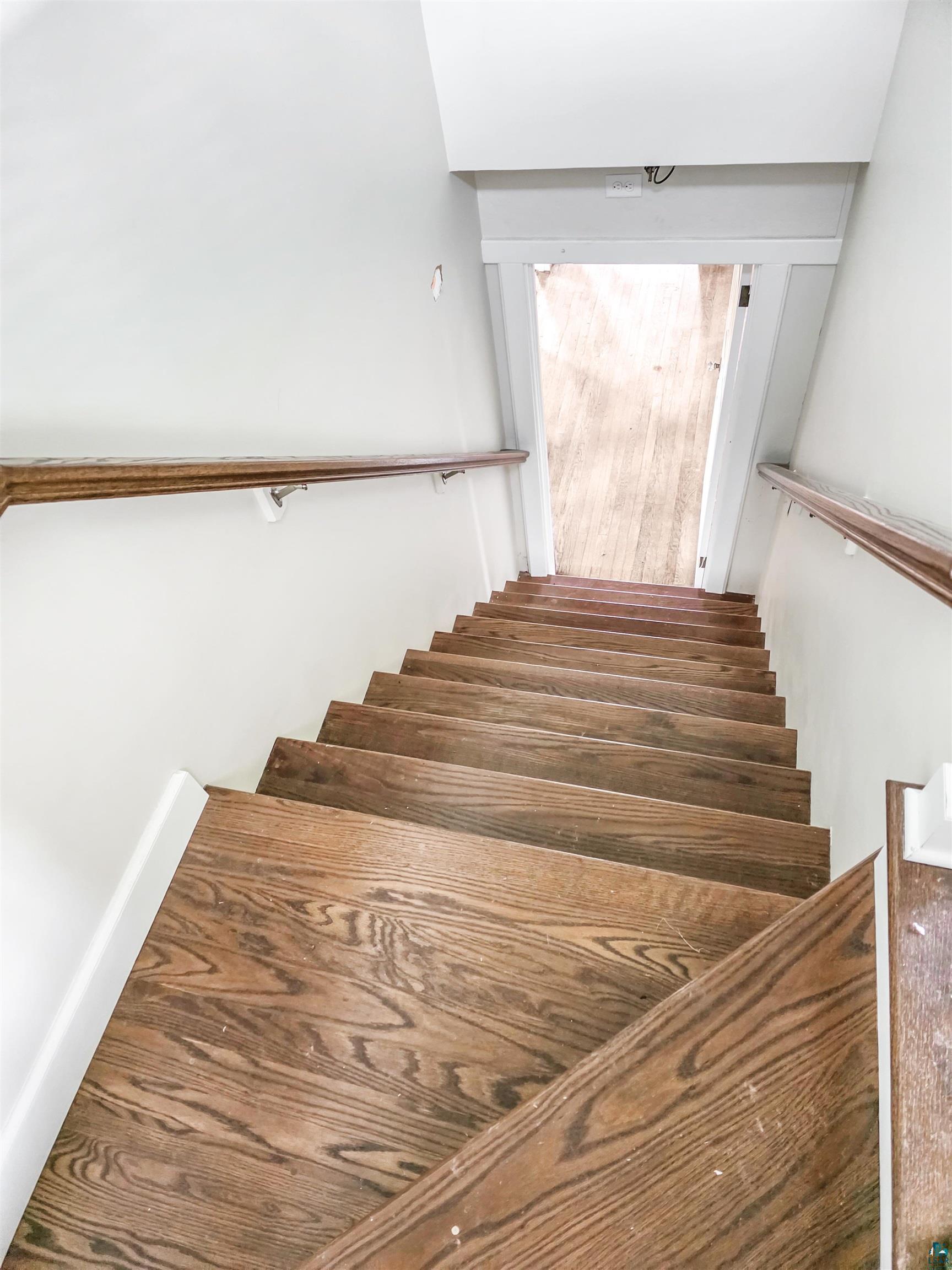 939 Whitefish Street La Pointe, WI 54850 - Photo 12 of 30 Staircase featuring dark wood-finish treads and risers with white trim