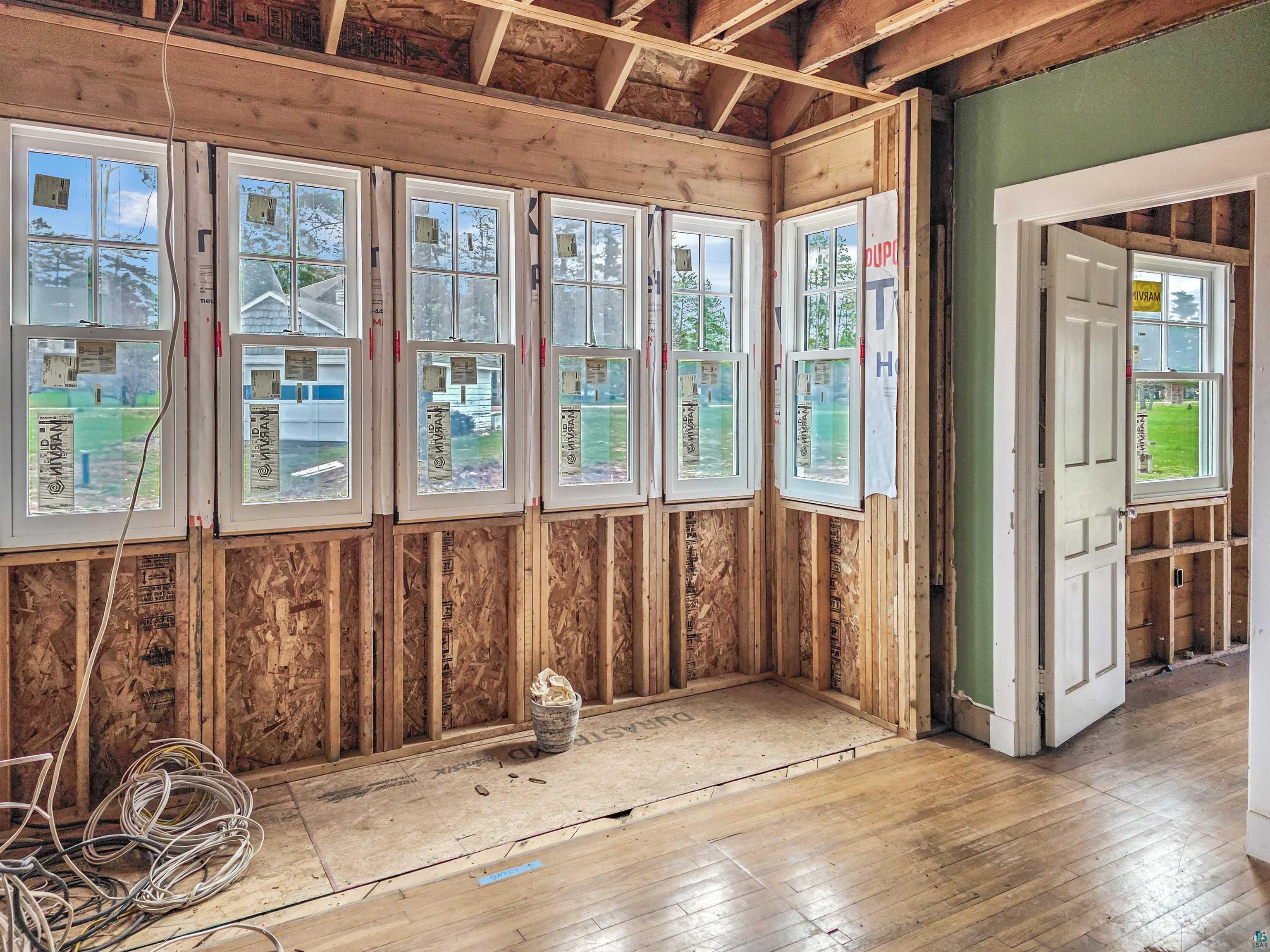 939 Whitefish Street La Pointe, WI 54850 - Photo 18 of 30 Room featuring exposed wood framing, multiple new white-framed windows, and existing wood-finish flooring