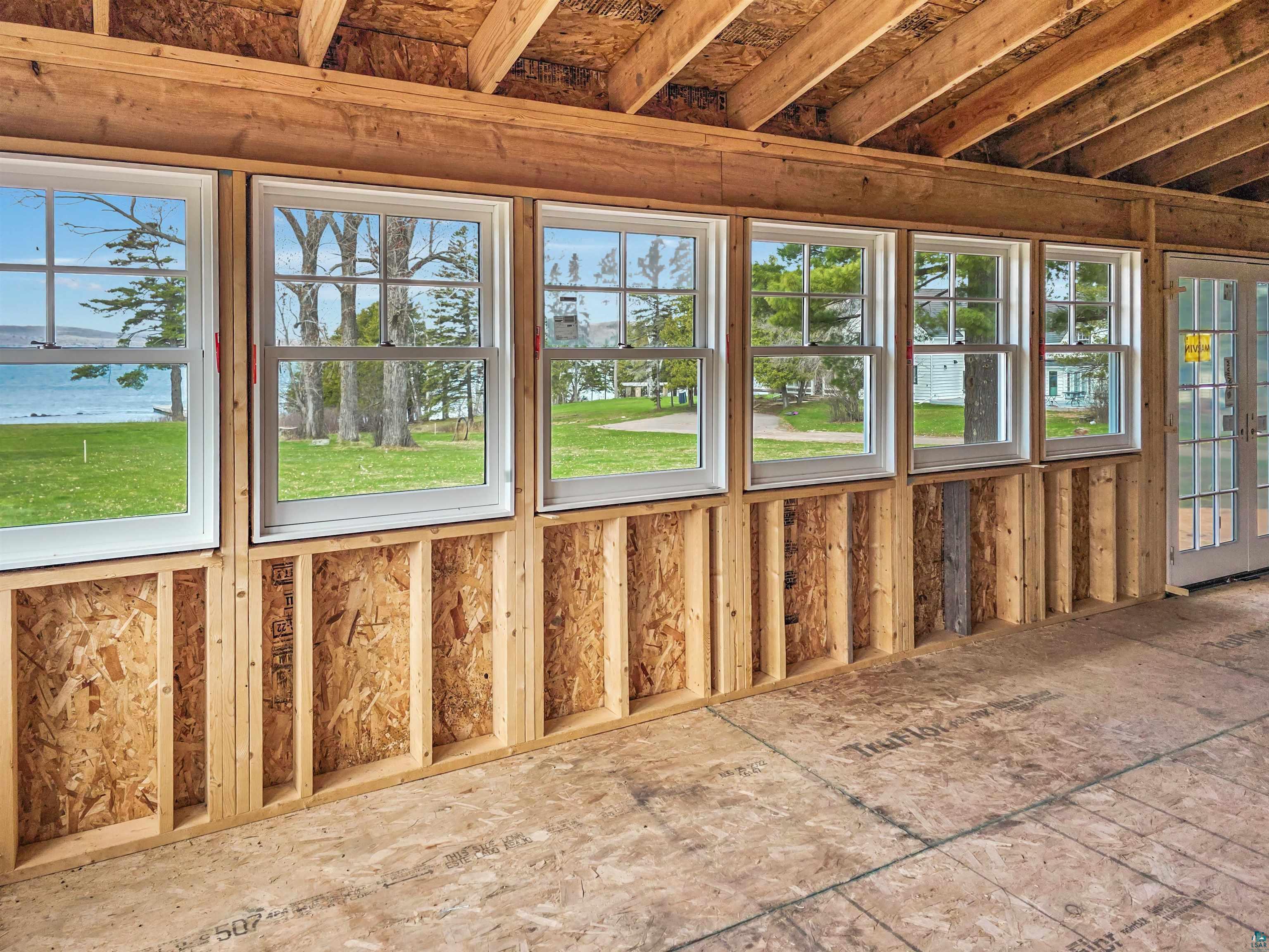 939 Whitefish Street La Pointe, WI 54850 - Photo 20 of 30 Multiple white-framed windows and a glass-paneled door provide abundant natural light and an open feel