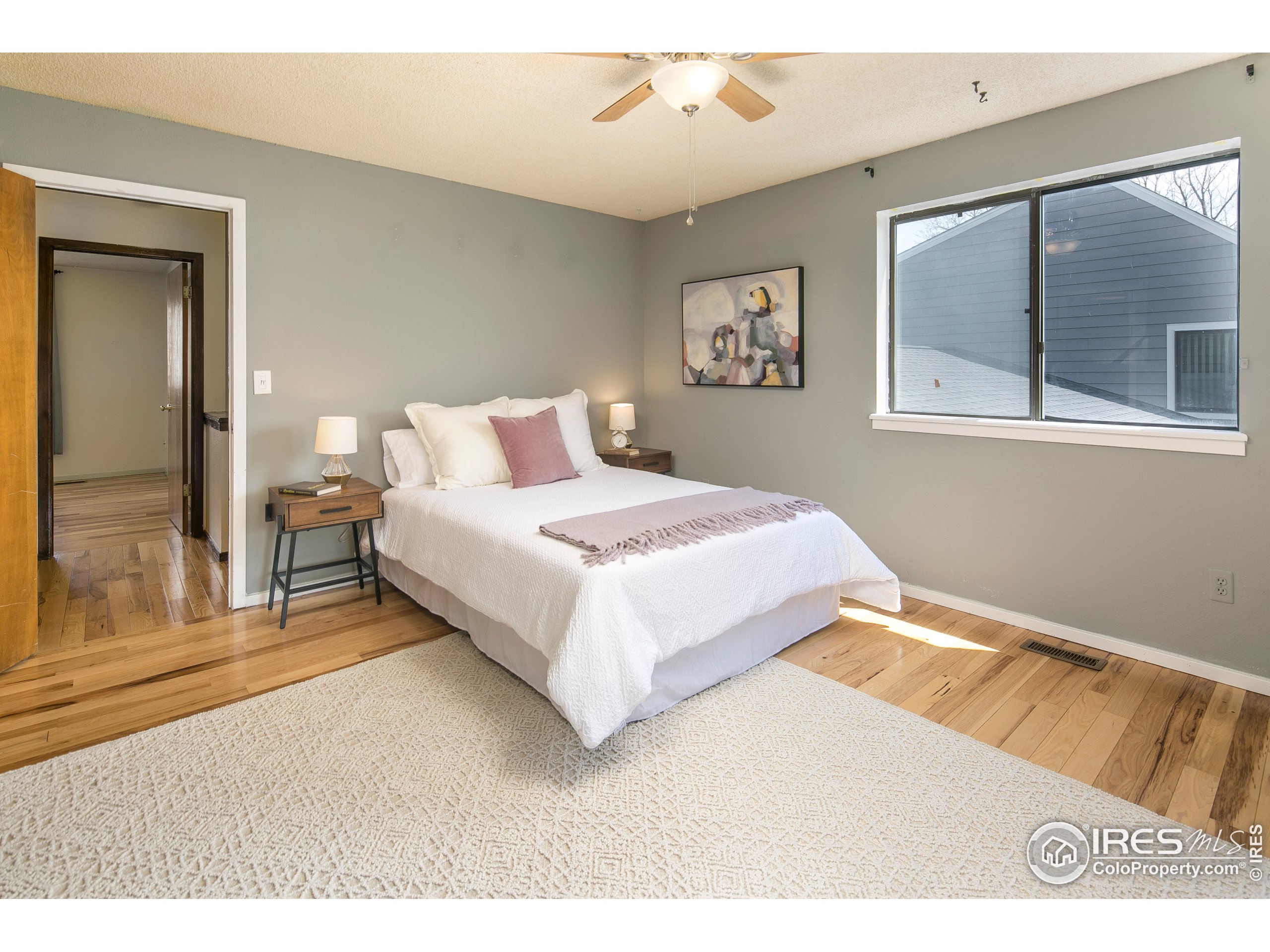 595 West Street Louisville, CO 80027 - Photo 13 of 26 a bedroom with a bed lamp and large window