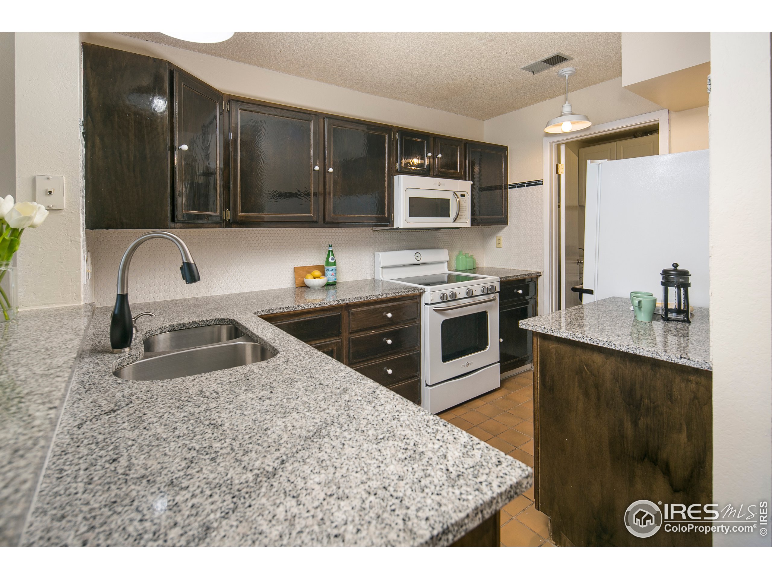 595 West Street Louisville, CO 80027 - Photo 5 of 26 a kitchen with stainless steel appliances granite countertop a sink stove and refrigerator