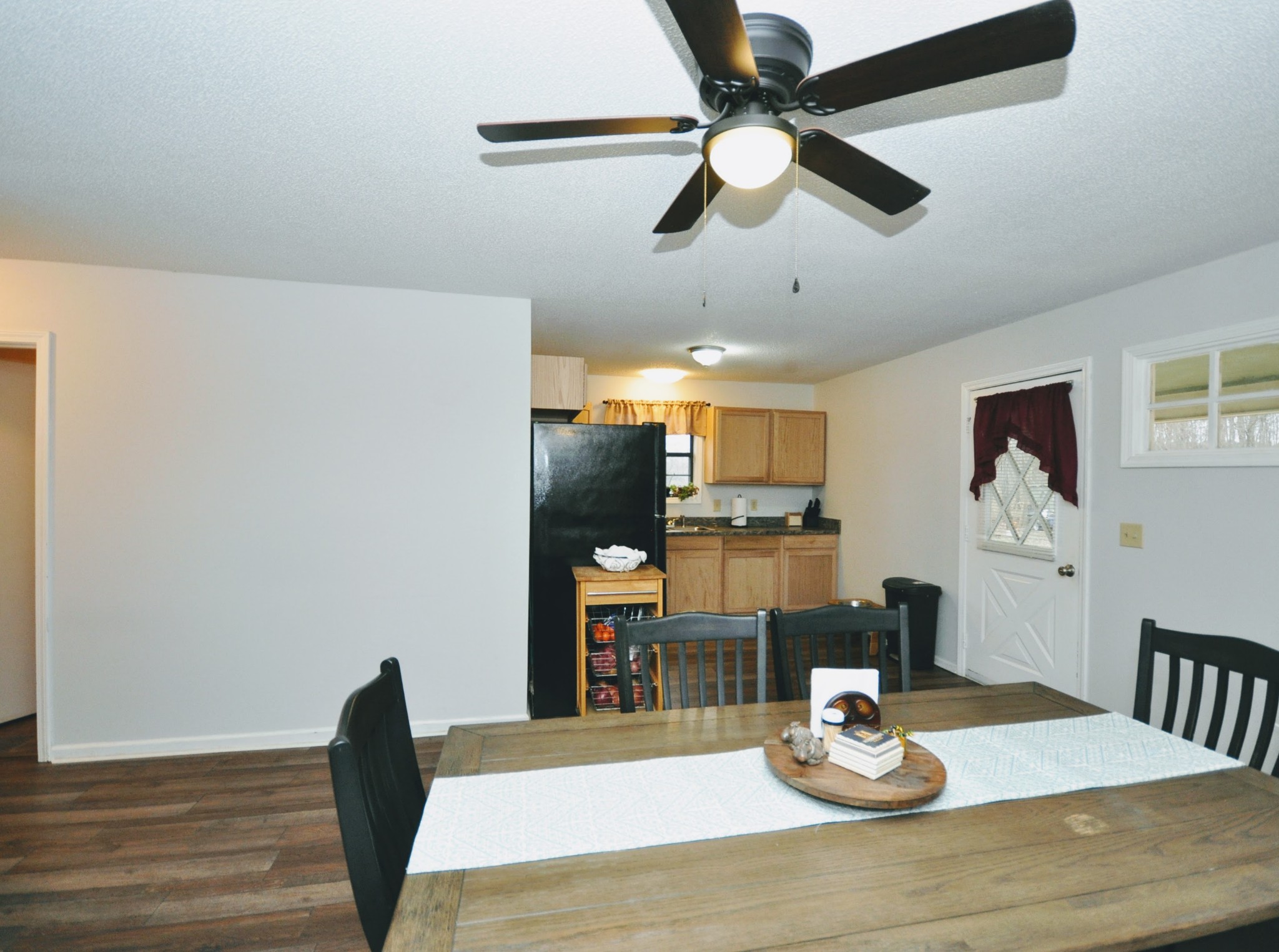 290 Lakeview Manor Road Springville, TN 38256 - Photo 21 of 36 a dining room with wooden floor a chandelier fan a wooden table and chairs