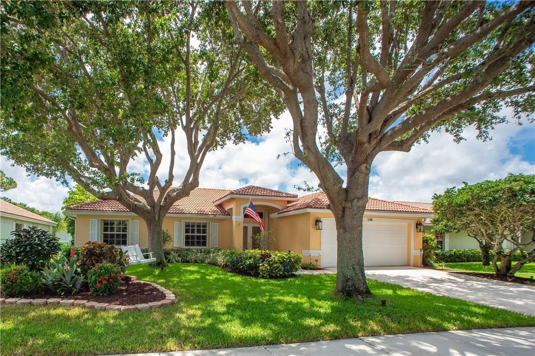 108 West Lee Road Delray Beach, FL 33445 - Photo 2 of 32 a front view of a house with a garden and trees