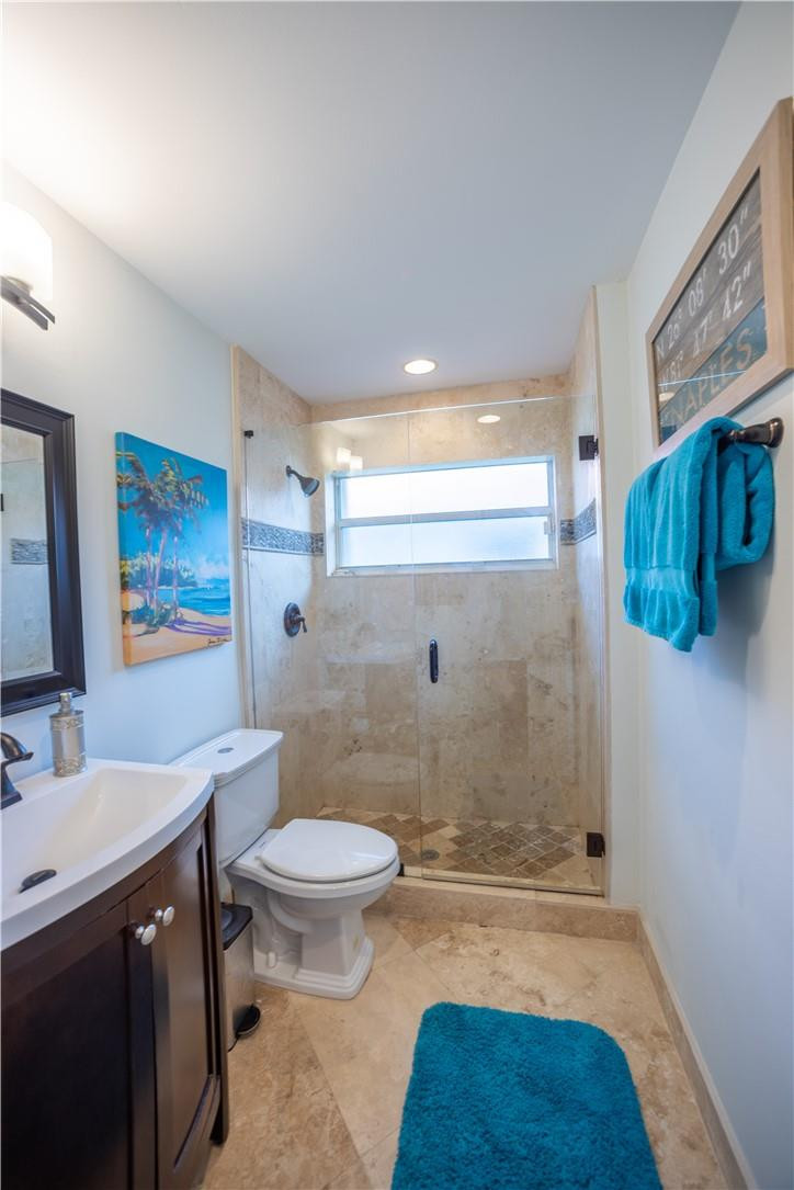 108 West Lee Road Delray Beach, FL 33445 - Photo 23 of 32 a bathroom with a granite countertop sink a toilet a mirror and shower