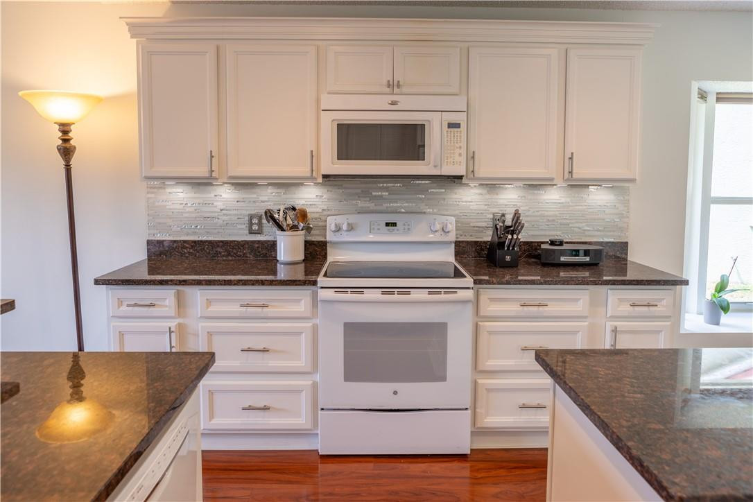 108 West Lee Road Delray Beach, FL 33445 - Photo 6 of 32 a kitchen with granite countertop white cabinets and white appliances