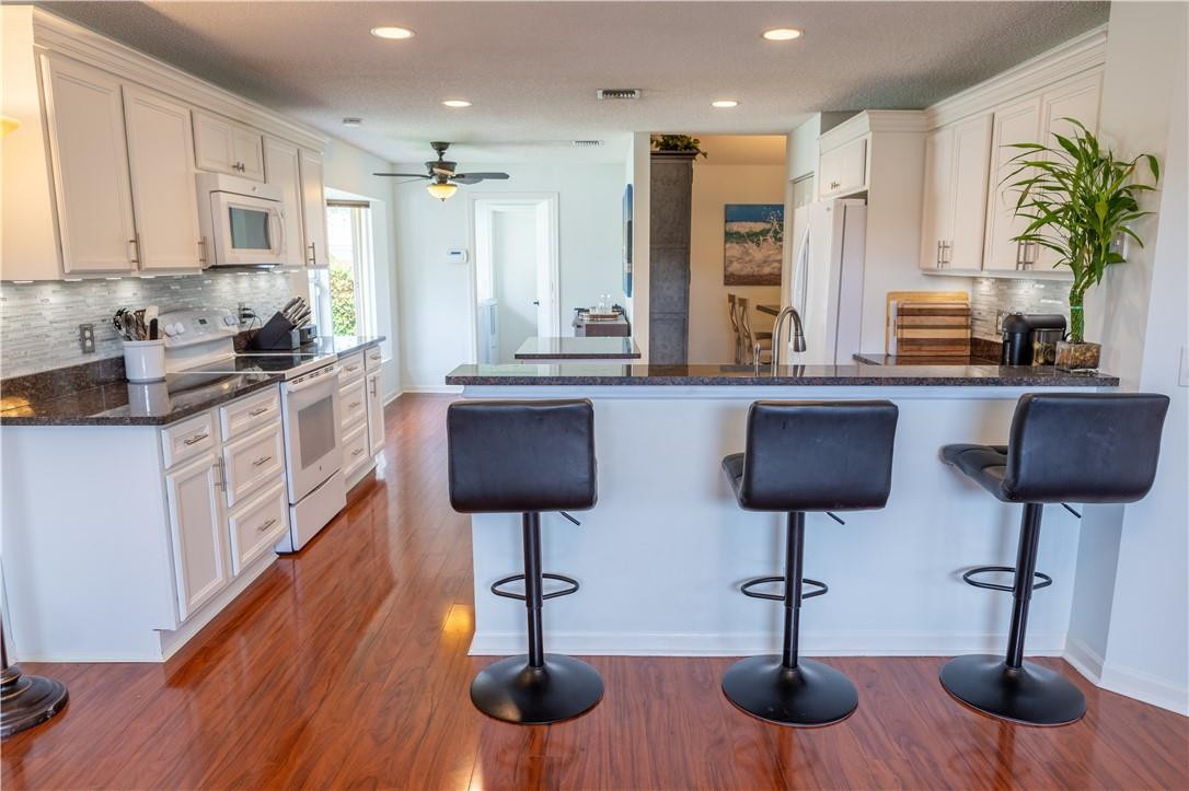 108 West Lee Road Delray Beach, FL 33445 - Photo 8 of 32 a kitchen with stainless steel appliances kitchen island a stove a sink a oven a counter space and chairs
