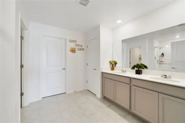 a spacious bathroom with a double vanity sink and mirror