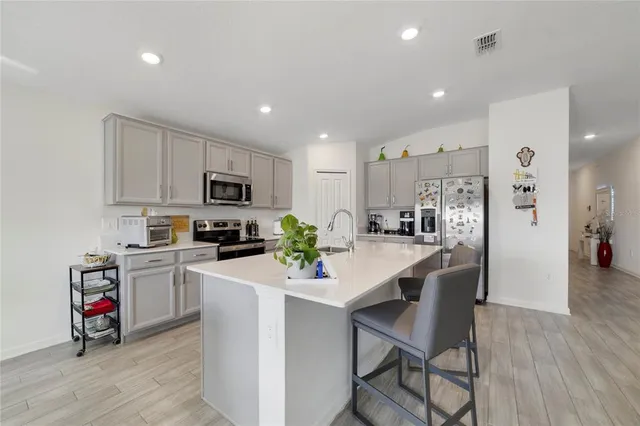 a kitchen with white cabinets stove and refrigerator