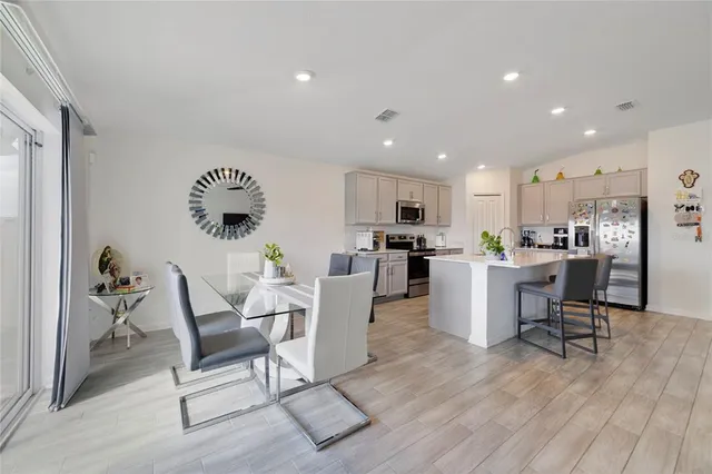 a living room with furniture and kitchen view with wooden floor