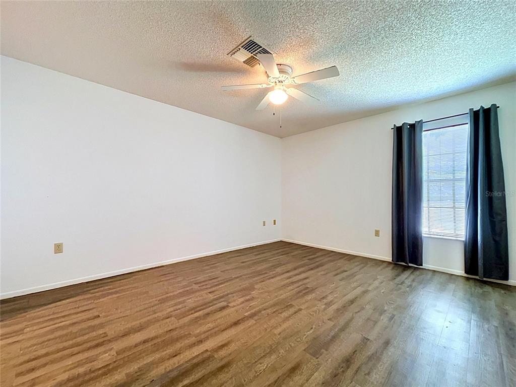 9319 Trowbridge Court New Port Richey, FL 34655 - Photo 41 of 78 a view of an empty room with wooden floor and a window